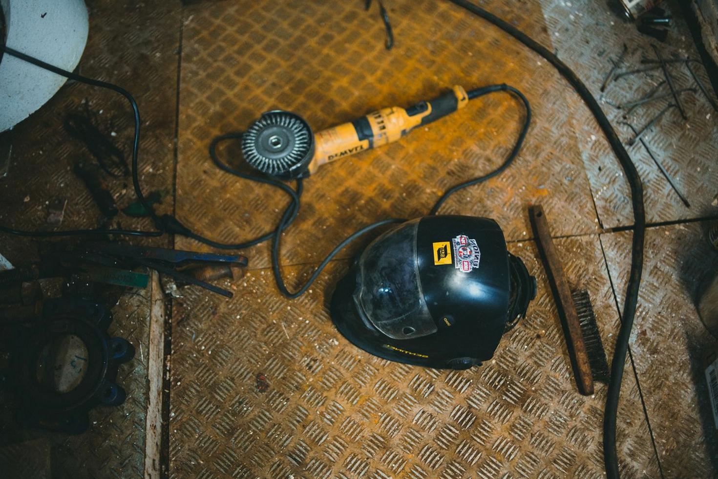 Angle grinder and welding helmet in a workshop